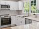 Modern kitchen features granite countertops, stainless steel appliances, and bright white cabinets at 1420 Fieldgreen Overlook, Stone Mountain, GA 30088