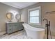 Bright bathroom features a double sink vanity, round mirrors, a soaking tub and a window at 1675 Bouldercliff Se Ct, Atlanta, GA 30316