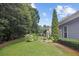 Well-maintained backyard with vibrant green lawn, manicured landscaping, and privacy provided by mature trees at 308 Shade Tree Cir, Woodstock, GA 30188