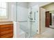 Glass-enclosed shower with a built-in bench, safety bars, ceramic tiling and a nearby walk-in closet at 308 Shade Tree Cir, Woodstock, GA 30188