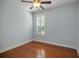 Cozy bedroom with hardwood floors, a ceiling fan, and a window with plantation shutters at 308 Shade Tree Cir, Woodstock, GA 30188