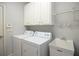 Functional laundry room with modern appliances, overhead cabinets, and utility sink at 308 Shade Tree Cir, Woodstock, GA 30188