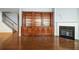 Living room with hardwood floors, a fireplace, a built-in bookcase, and stairs leading to the second floor at 308 Shade Tree Cir, Woodstock, GA 30188