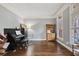 Cozy living room featuring hardwood floors, piano, and natural light from the windows at 5410 Cottage Farm Rd, Alpharetta, GA 30022