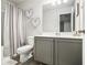 Bathroom featuring vanity with grey cabinets, mirror, modern lighting, and shower with curtain at 7086 Gladstone Cir, Lithonia, GA 30038
