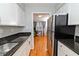 Galley-style kitchen featuring granite counters, white cabinets, and stainless steel appliances at 1150 Collier Nw Rd # B5, Atlanta, GA 30318