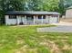 Charming single-story home with a welcoming front porch and an attached single car garage at 256 New Hope Rd, Lawrenceville, GA 30046