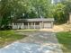 Home exterior featuring a front porch, attached garage, and spacious front yard at 256 New Hope Rd, Lawrenceville, GA 30046
