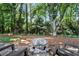 Cozy backyard fire pit with seating, surrounded by lush landscaping and mature trees at 2845 Burgundy Dr, Cumming, GA 30041