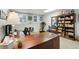 Finished basement featuring a home office area with a large wooden desk and built in shelving unit with books at 2845 Burgundy Dr, Cumming, GA 30041