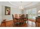 Formal dining room with chandelier, wood floors, and elegant window views at 2845 Burgundy Dr, Cumming, GA 30041