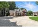Charming two-story brick home featuring a circular driveway, attached garage, and meticulously maintained landscaping at 2845 Burgundy Dr, Cumming, GA 30041