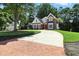 Charming brick home with a circular driveway, mature trees, and well-maintained landscaping at 2845 Burgundy Dr, Cumming, GA 30041
