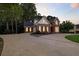 Elegant brick home with a circular driveway, lush landscaping, and ample parking at 2845 Burgundy Dr, Cumming, GA 30041