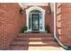 Elegant brick entryway with potted plants, sconces, and leaded glass front door at 2845 Burgundy Dr, Cumming, GA 30041