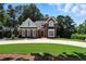 Beautiful brick home with a circular driveway and perfectly manicured lawn on a sunny day at 2845 Burgundy Dr, Cumming, GA 30041