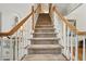 Elegant staircase with carpeted steps and wooden banister, leading to the upper level at 2845 Burgundy Dr, Cumming, GA 30041