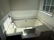 Relax in this soaking tub with tile surround and a large window bringing in lots of natural light at 4189 Post Oak Grv, Atlanta, GA 30349