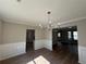 Formal dining room features wainscoting, modern chandelier, and updated luxury vinyl plank flooring at 4189 Post Oak Grv, Atlanta, GA 30349