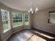 Formal dining room features large windows, modern chandelier, and luxury vinyl plank flooring at 4189 Post Oak Grv, Atlanta, GA 30349