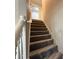 Carpeted staircase with white railing leading to the upper level at 4189 Post Oak Grv, Atlanta, GA 30349