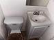 Tight view of a bathroom with white toilet, small white vanity with a sink, and a mirror at 1373 Lucile Sw Ave, Atlanta, GA 30310