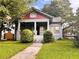 Inviting two-story home featuring a classic front porch, mature trees, and lush landscaping at 1373 Lucile Sw Ave, Atlanta, GA 30310