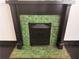 Close up of an antique fireplace with green tiles and black trim at 1373 Lucile Sw Ave, Atlanta, GA 30310