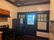 Kitchen area with black oven, refrigerator, dark trim, overhead vent, and wood flooring at 1373 Lucile Sw Ave, Atlanta, GA 30310