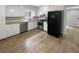 Well-lit kitchen featuring white cabinets, stainless steel appliances, and wood-look floors at 3867 Cherie Glen Rd, Snellville, GA 30039