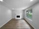 Bright living room with neutral gray walls, a cozy fireplace, and gleaming wood floors at 3867 Cherie Glen Rd, Snellville, GA 30039