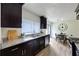 Modern kitchen boasts granite countertops, dark wood cabinetry, stainless steel appliances, and a cozy dining area at 183 Peachtree Ct, Riverdale, GA 30274