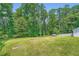 A backyard with an expansive lawn and natural elements like trees and shrubs at 5190 Due West Nw Rd, Powder Springs, GA 30127