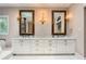 Bathroom featuring double vanity, patterned wallpaper, and sconce lighting at 5190 Due West Nw Rd, Powder Springs, GA 30127