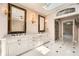 Bathroom with tiled floor, dual vanities, sconce lighting, and skylight at 5190 Due West Nw Rd, Powder Springs, GA 30127