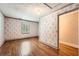 Bedroom with hardwood floors, patterned wallpaper, and natural light at 5190 Due West Nw Rd, Powder Springs, GA 30127