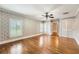 Bright bedroom featuring hardwood floors, plantation shutters, and access to closets at 5190 Due West Nw Rd, Powder Springs, GA 30127