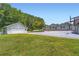 Spacious home featuring a large driveway and attached garage, surrounded by lush greenery at 5190 Due West Nw Rd, Powder Springs, GA 30127