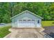 Detached garage with a multiple-door garage door, a side entrance, and well maintained landscaping at 5190 Due West Nw Rd, Powder Springs, GA 30127