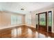 Bright living room featuring hardwood floors, plantation shutters, and a decorative front door at 5190 Due West Nw Rd, Powder Springs, GA 30127