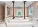 Large bathtub with decorative pillars and tile surround at 5190 Due West Nw Rd, Powder Springs, GA 30127