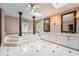 Elegant bathroom with tiled floor, sunken tub, dual vanities, and decorative pillars at 5190 Due West Nw Rd, Powder Springs, GA 30127