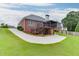 Sprawling backyard featuring a brick home, deck, and expansive green lawn at 995 Lewis Ridge Cir, Lawrenceville, GA 30045