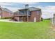 Spacious backyard showcasing a brick home with a screened porch, deck, and a well-maintained lawn at 995 Lewis Ridge Cir, Lawrenceville, GA 30045