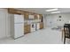 Basement kitchen features white appliances, tile flooring, and light wood cabinets at 995 Lewis Ridge Cir, Lawrenceville, GA 30045