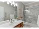 A clean bathroom with tile flooring, a marble shower, and a wood vanity at 995 Lewis Ridge Cir, Lawrenceville, GA 30045