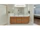Bathroom with dual sinks, white tile floors, a glass shower, and a glimpse into the Primary bedroom at 995 Lewis Ridge Cir, Lawrenceville, GA 30045