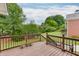 A wooden deck with stairs overlooking green grass, trees, and brick home at 995 Lewis Ridge Cir, Lawrenceville, GA 30045