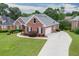 Well-maintained brick home featuring a side-entry garage, long driveway, and manicured landscaping at 995 Lewis Ridge Cir, Lawrenceville, GA 30045