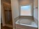 Modern bathroom features a soaking tub with tile surround and separate glass shower at 5311 Tuscany Dr, Douglasville, GA 30135
